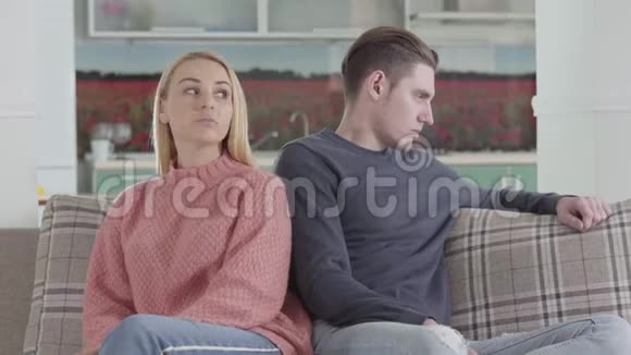 积极的高加索女人给配偶一个小小的手指以求和平年轻的争吵夫妇坐在沙发上视频的预览图