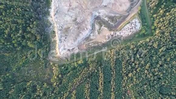 在森林里的一个小垃圾填埋场上空飞行道路在废墟之间穿行视频的预览图