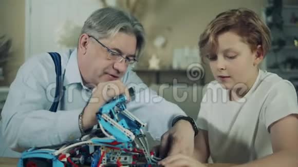 一个男孩和他爷爷正在摆设一辆玩具车视频的预览图