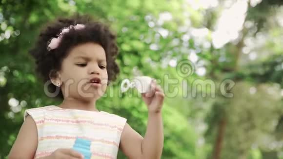 非洲裔美国女孩在公园吹肥皂泡的特写镜头视频的预览图