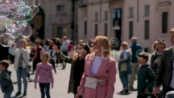 欢快的女人呆在广场上和其他人一起捕捉肥皂泡的视频在罗马度假视频视频的预览图
