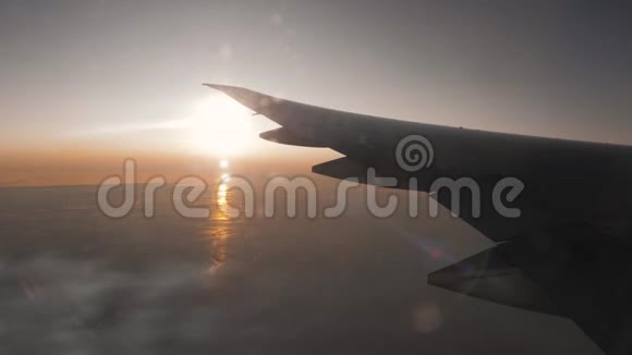 从窗外看飞机在日落的高度飞行的机翼视频的预览图