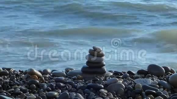禅石堆在海滩上后面有海浪视频的预览图