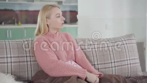 镜头接近坐在家里沙发上的美丽愤怒的女人的脸室内压力大的女孩的肖像视频的预览图