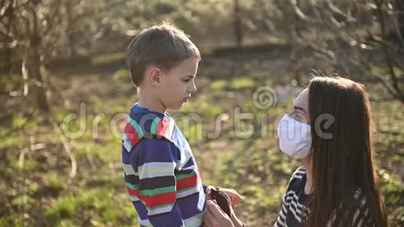 细心的母亲给儿子戴上口罩以防病毒视频的预览图
