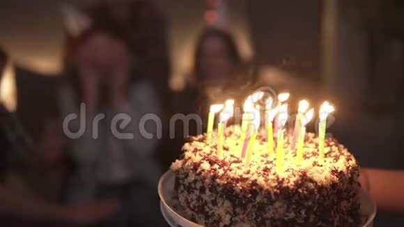 特写镜头用燃烧的蜡烛关注生日蛋糕幸福的微笑卷曲的红头发女孩期待惊喜视频的预览图