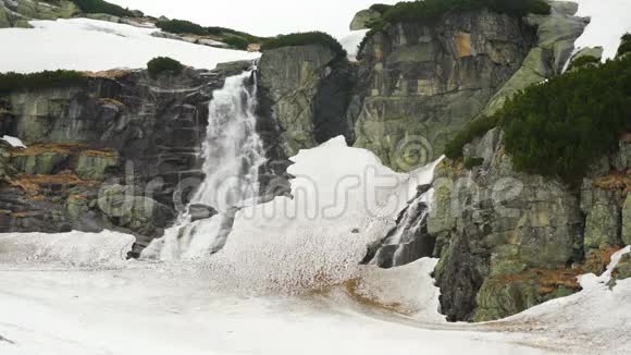 瀑布斯洛伐克高塔特拉斯的Skok在春天阴天岩石仍然覆盖着雪视频的预览图