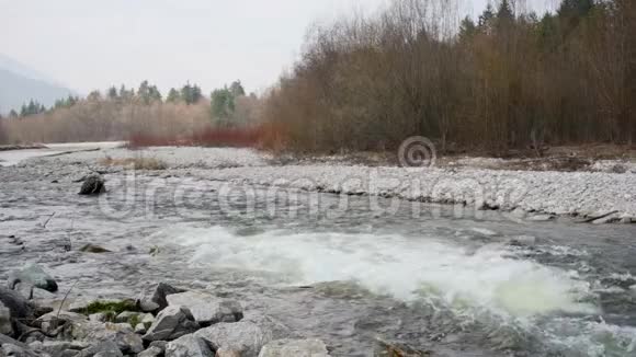慢动作视频泉水在河中流淌水流湍急会产生白浪背景是树木视频的预览图