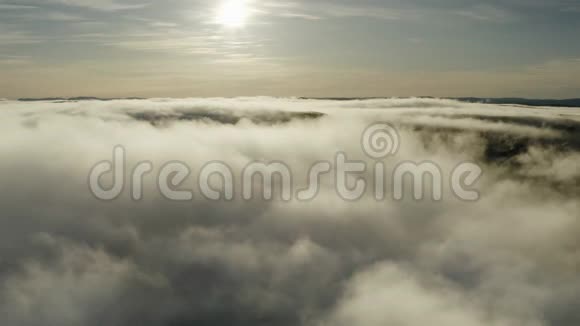飞上厚厚的蓬松的冬云和硕大的冬阳以晴朗的蓝天然后降落到云层上霜冻之上的日落视频的预览图