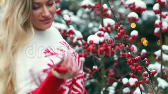 在圣诞树和红浆果背景下街头的女孩视频的预览图