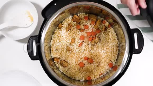 把煮熟的米饭蔬菜和肉混合在一起大米皮拉夫食谱在高压锅中用肉类和蔬菜煮饭视频的预览图