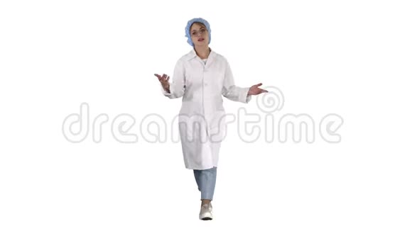友好的女医生在白色背景下步行和与相机交谈视频的预览图