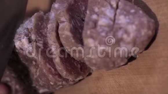 一把大菜刀在木板上割下一卷冻肉视频的预览图