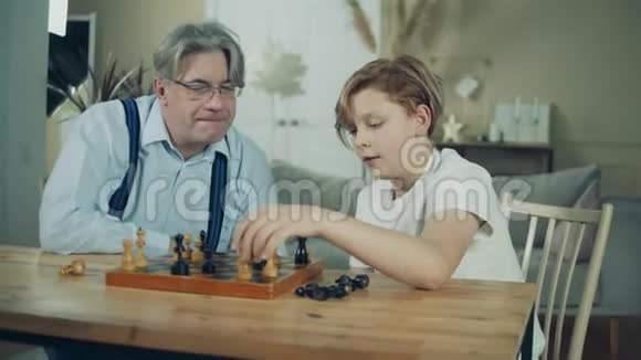 一个男孩和他爷爷正在谈论象棋视频的预览图