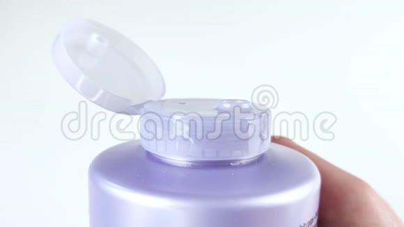 手指关闭紫色瓶子的盖子洗发水护发素沐浴露沐浴泡沫保湿护肤乳液自然视频的预览图