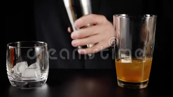 威士忌酸鸡尾酒酒保拿着摇床打开它把冰从勺子里倒进去把杯子里的东西倒进去视频的预览图