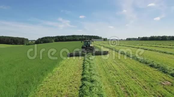 农民在拖拉机上割草为干草或牲畜提供饲料鸟瞰图视频的预览图