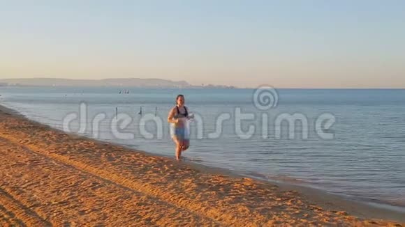 穿短裤的布鲁内特女士在海滨晨跑视频的预览图