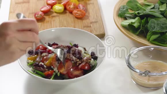 小菠菜沙拉配西红柿小红莓山核桃蓝芝士和覆盆子酱放在厨房桌子的碗里视频的预览图