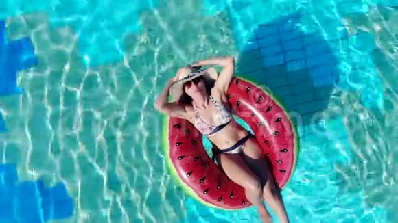 休息的女人漂浮在游泳池里的橡胶圈上暑假概念视频的预览图