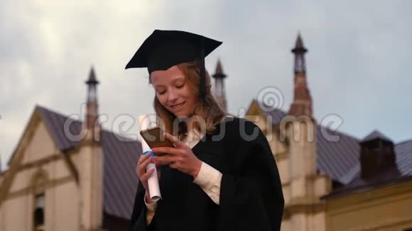 穿着毕业礼服在手机上发短信视频的预览图