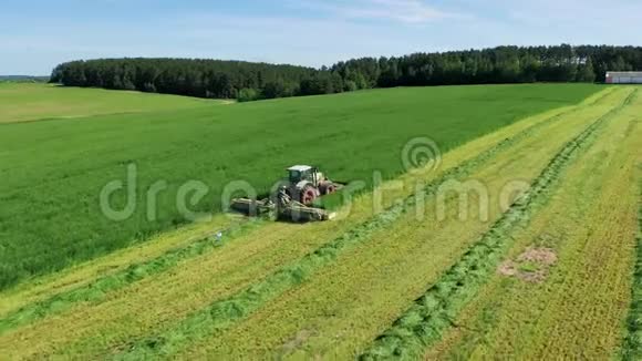 农夫在拖拉机上割草为干草或青贮饲料鸟瞰视频的预览图