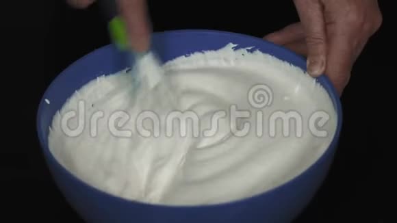 特写镜头老年妇女手中的鞭子奶油蛋糕视频的预览图
