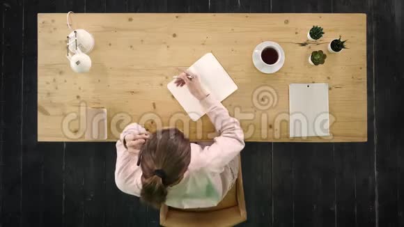 工作中的临时妇女在工作场所打电话和做笔记坐在工作场所视频的预览图