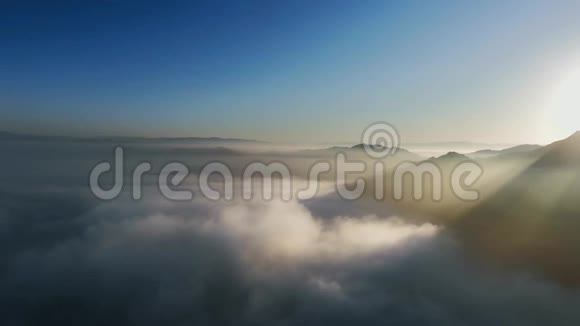 在滚滚的云层和山峰附近的阳光鸟瞰视频的预览图