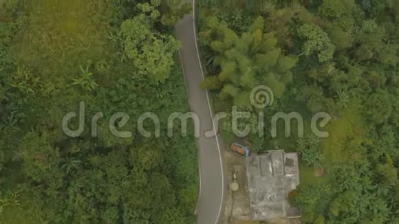 空中建立汽车在山区雨林道路上行驶的镜头视频的预览图