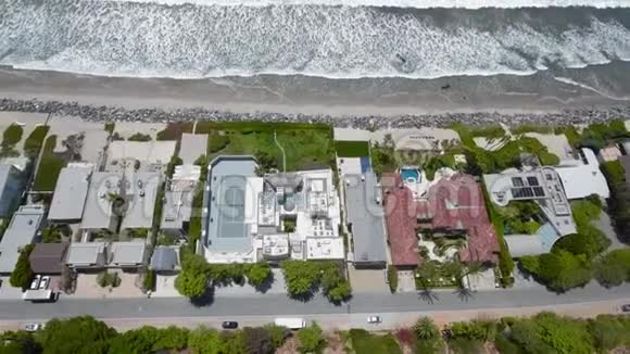 无人机飞越房屋海滩和海浪视频的预览图