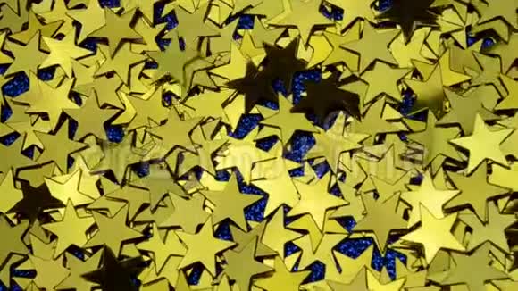 金色的黄色纸屑以不同的角度闪耀摇动抛掉落下来的经典蓝色闪光背景的星星视频的预览图