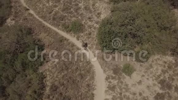 骑自行车在乡村景观上从无人驾驶飞机上击落飞机视频的预览图