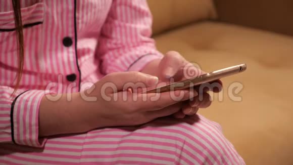电话在一个穿着粉红色睡衣的女人手里视频的预览图