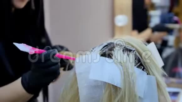 在沙龙里染发年轻漂亮的金发碧眼的金发女郎在理发店染发视频的预览图