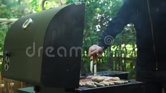 人在烧烤炉上煮肉和香肠视频的预览图