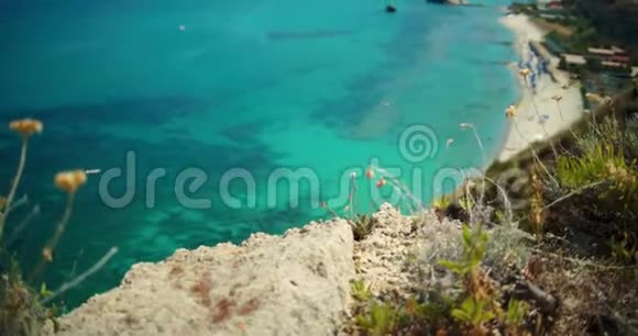 令人惊叹的景观从悬崖覆盖灌木在酒店海滩与绿松石蓝水慢镜头视频的预览图
