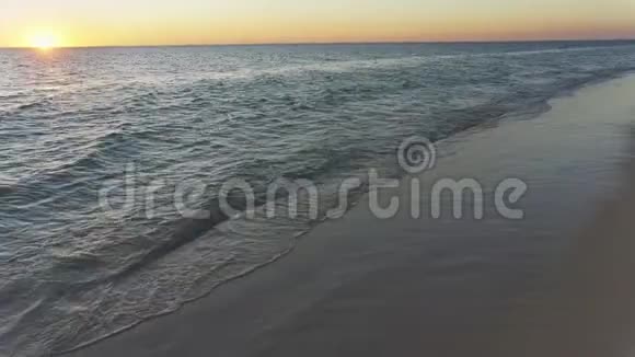 平静的大海带着小浪太阳远远地落在地平线上视频的预览图
