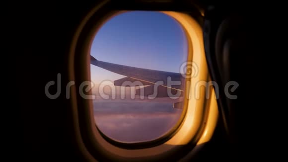 从窗外飘过猩红日落的天空的飞机飞行之翼视频的预览图