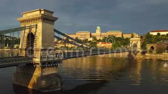 匈牙利布达佩斯日出时Szechenyi链桥与多瑙河和布达城堡皇家宫殿的4K鸟瞰图视频的预览图