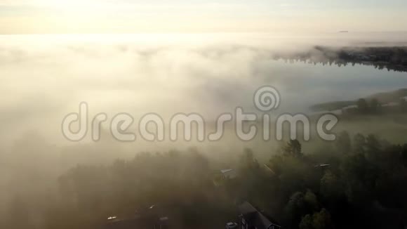 不错的空中视频无人驾驶飞机通过厚厚的雾云飞到湖边然后飞到明媚的地方瑞典的乡村景观视频的预览图