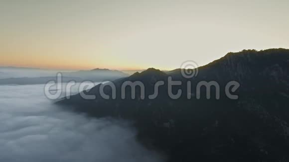 无人机照相机飞过美丽的云层拍摄隐藏在山后的太阳视频的预览图