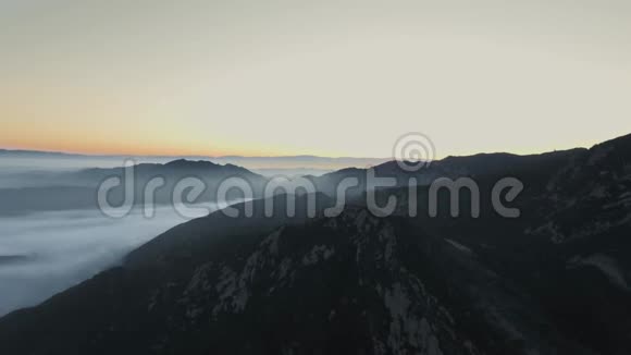 日出时用浓雾覆盖着茂密森林的山景观视频的预览图