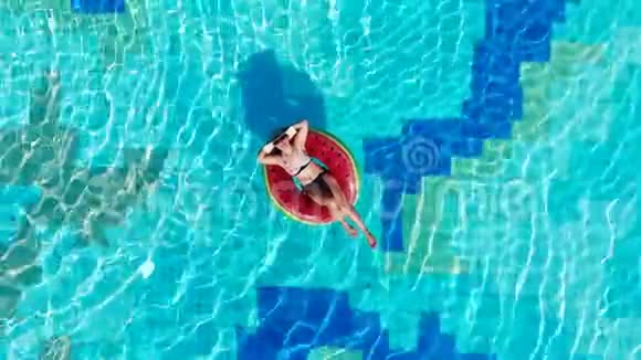女人在游泳池里休息漂浮在橡胶圈上视频的预览图