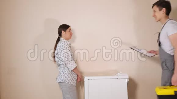 服务员拜访家庭主妇检查房间里的洗衣机视频的预览图