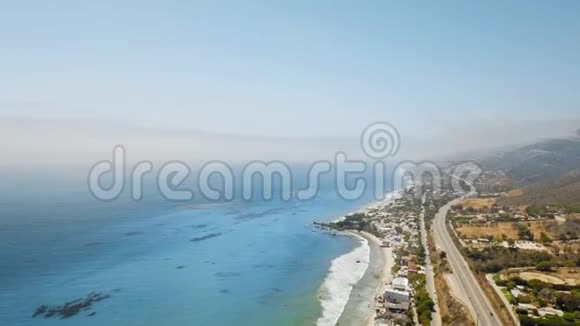 无人机照相机拍摄多云地平线蓝色海洋海岸沉降蜿蜒的道路与汽车和山视频的预览图