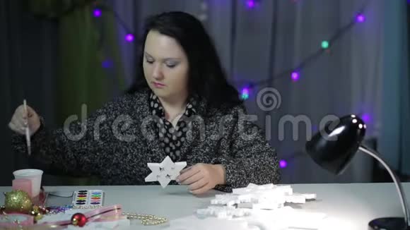 一个年轻的女人用颜料画星星来做圣诞节的家饰视频的预览图