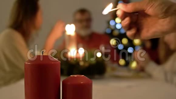 妇女点燃餐桌上的蜡烛用于圣诞节或新年晚餐餐桌和大家庭背景视频的预览图