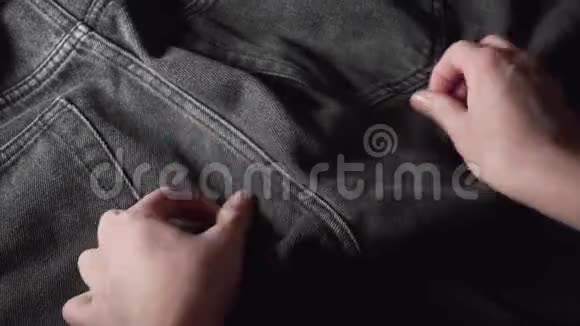 一个购物者检查黑色牛仔裤触摸织物的手在购买前检查质量视频的预览图