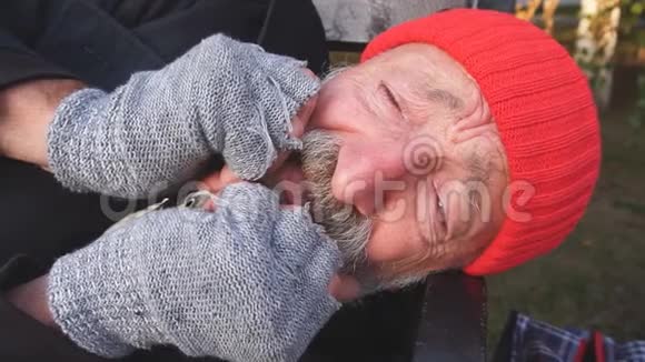 身无分文的老人躺在公园的长凳上从寒冷中颤抖着视频的预览图